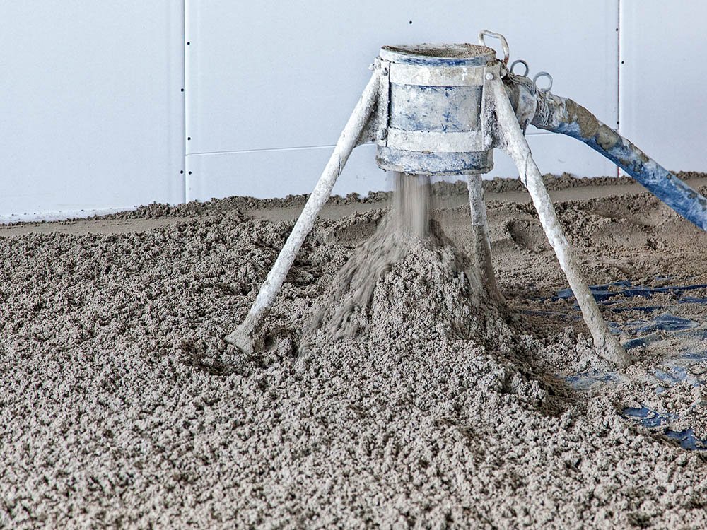 Maschinelles Einbringen von Estrich Frischer Estrich wird maschinell auf der Baustelle eingebracht